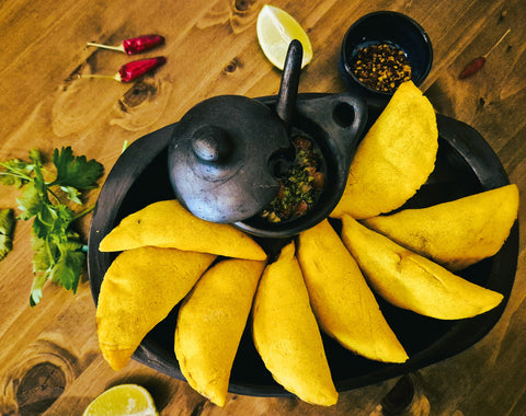Goldgelbe Empanadas angerichtet mit Koreander Salsa aus der Viva Sabor Kochbox