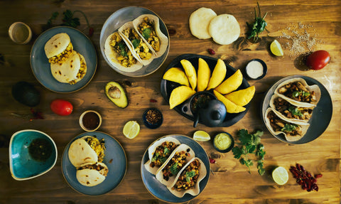 Tisch mit lateinamerikanischen Gerichten - Arepas, Empanadas und Tacos aus den Viva Sabor Kochboxen