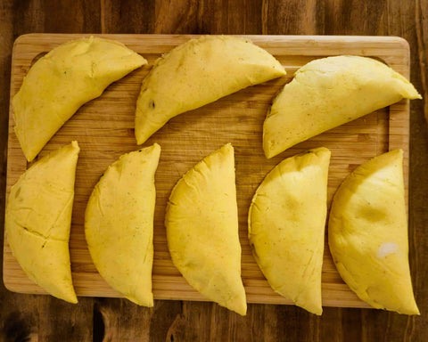 Handgemachte, schön geformte Empanadas aus gelbem Maismehl